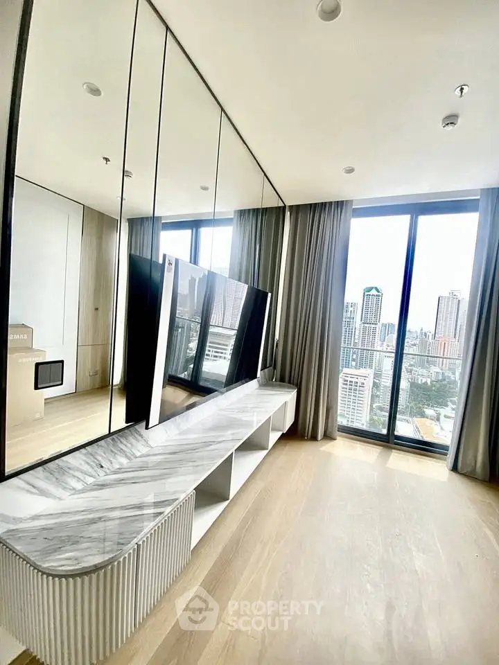 Luxurious living room with floor-to-ceiling windows offering stunning city views, modern decor, and elegant finishes.