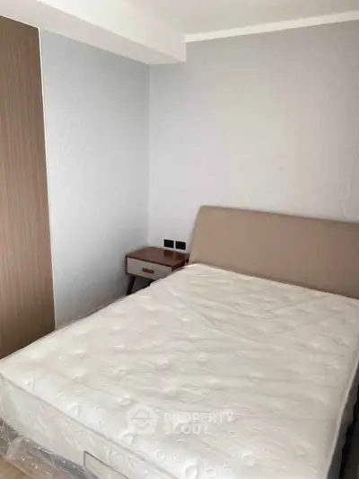 Modern bedroom with minimalist design featuring a comfortable bed and sleek nightstand.