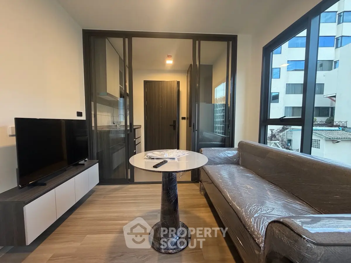 Modern living room with sleek furniture and large windows in a contemporary apartment.