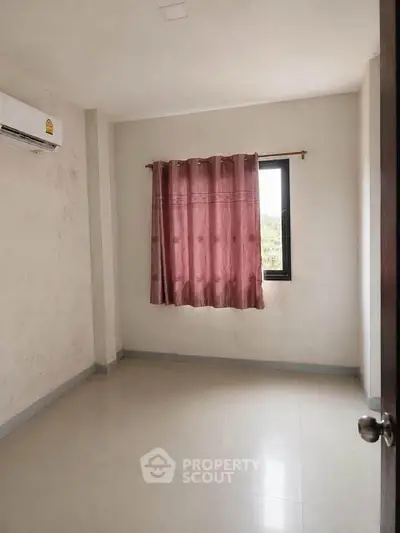 Spacious empty room with window and air conditioning, ideal for customization.