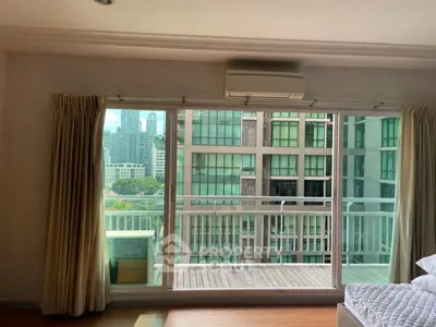 Spacious bedroom with balcony offering stunning city view in modern apartment