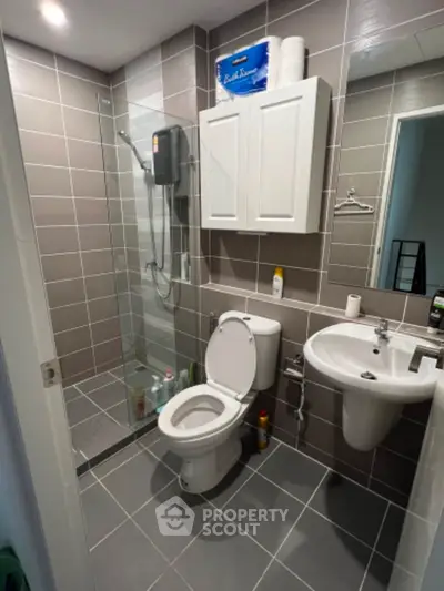 Modern bathroom with sleek design, featuring a glass shower enclosure and stylish fixtures.