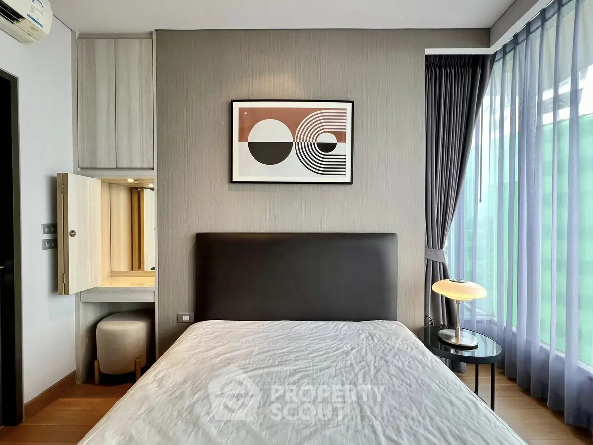 Modern bedroom with stylish decor and natural light, featuring a cozy bed and elegant furnishings.