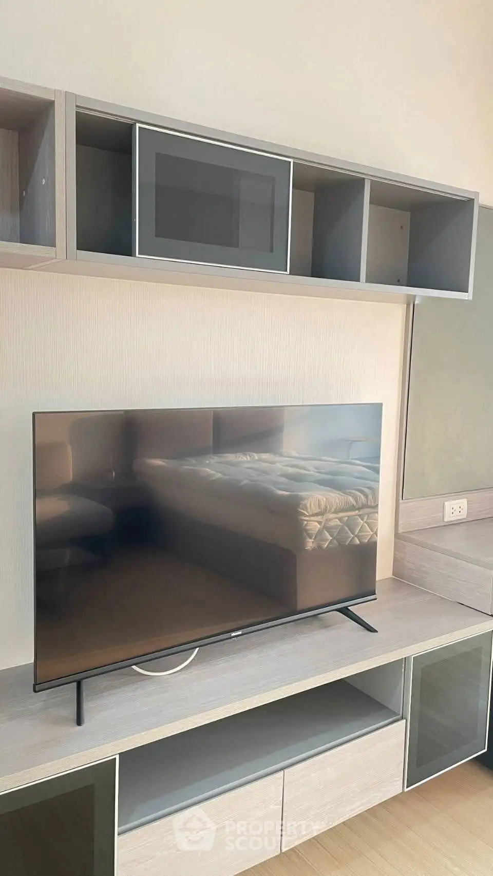 Modern living room with sleek TV stand and wall-mounted storage units.