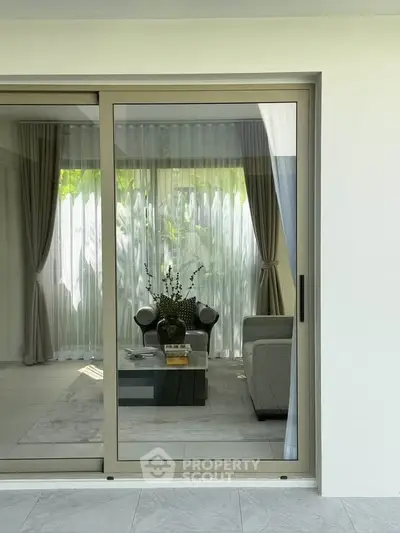 Elegant living room with sliding glass doors and modern decor, perfect for relaxation and entertaining.