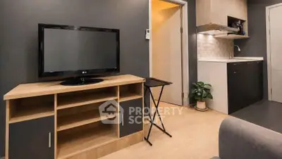 Modern living room with sleek TV stand and compact kitchen area, perfect for urban living.