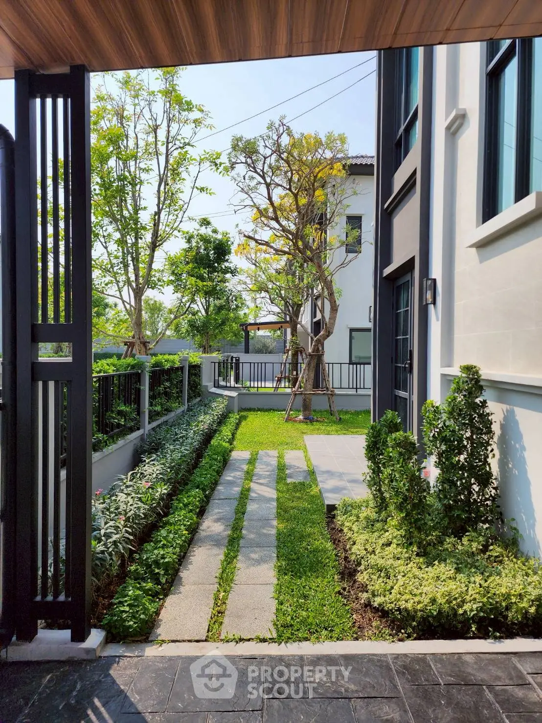 Charming garden view with lush greenery and modern architecture, perfect for serene outdoor living.