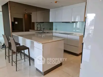 Modern kitchen with sleek white cabinets and island in luxury apartment