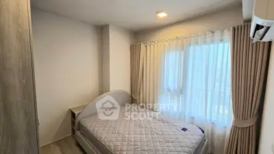 Cozy bedroom with natural light and modern furnishings in a stylish apartment.