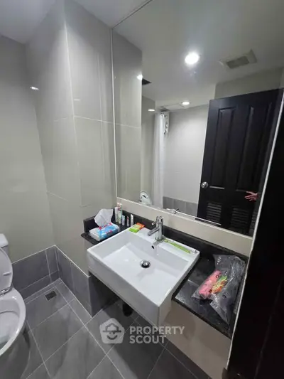 Modern bathroom with sleek sink and large mirror, ideal for contemporary living.