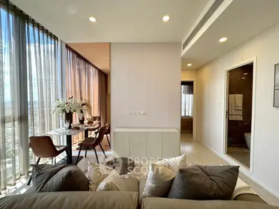 Luxurious modern living room with floor-to-ceiling windows and elegant dining area