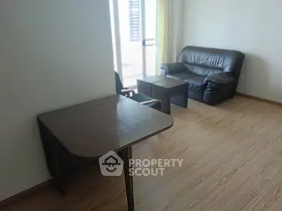Spacious living room with wooden flooring and cozy seating area, perfect for relaxation.
