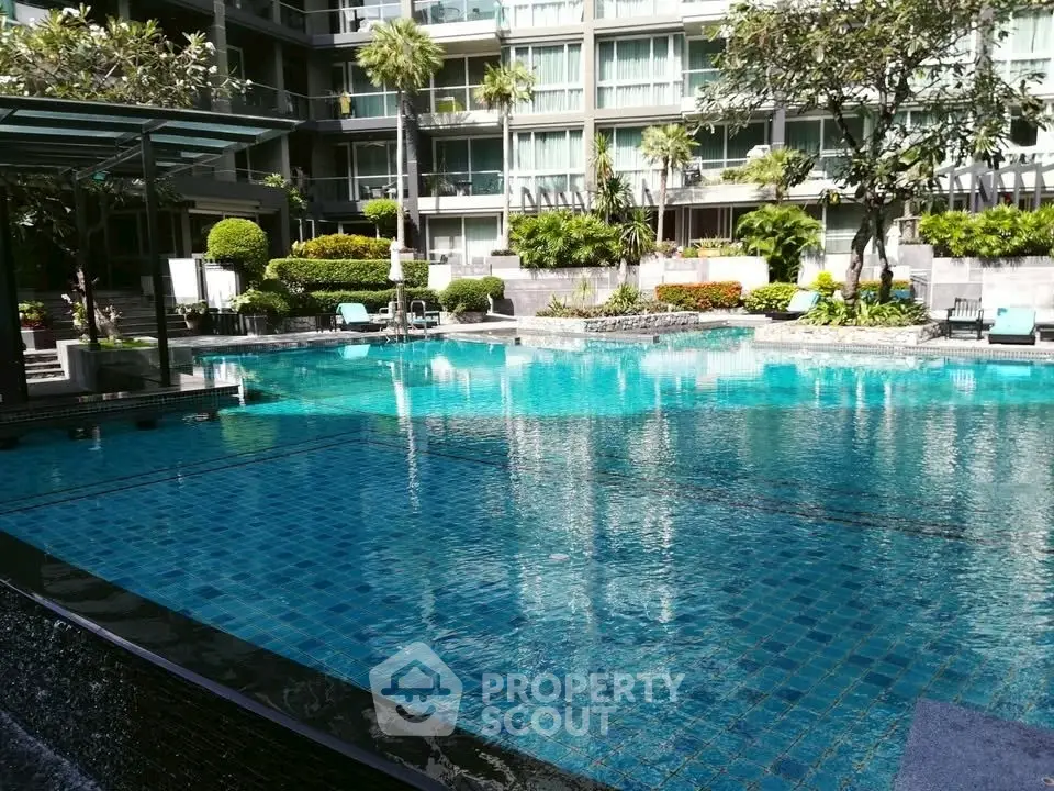 Luxurious condominium pool area with lush landscaping and modern design.