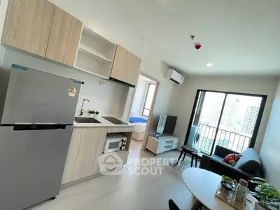 Modern open-layout kitchen and living area with city view balcony in a stylish apartment.