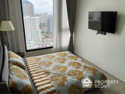 Modern bedroom with city view and wall-mounted TV in high-rise apartment