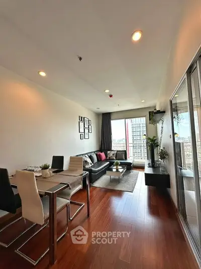 Modern living room with sleek furniture and city view, featuring hardwood floors and stylish decor.