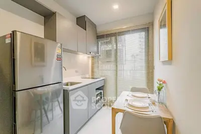 Modern kitchen with sleek cabinets and dining area in bright apartment