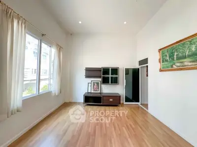 Spacious living room with wooden flooring and large window in modern apartment