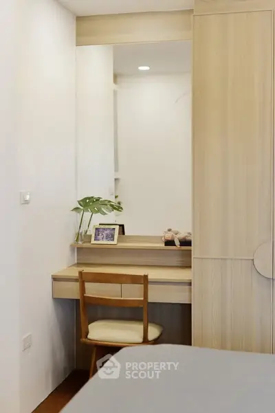 Cozy bedroom corner with wooden desk and chair, perfect for a study nook.