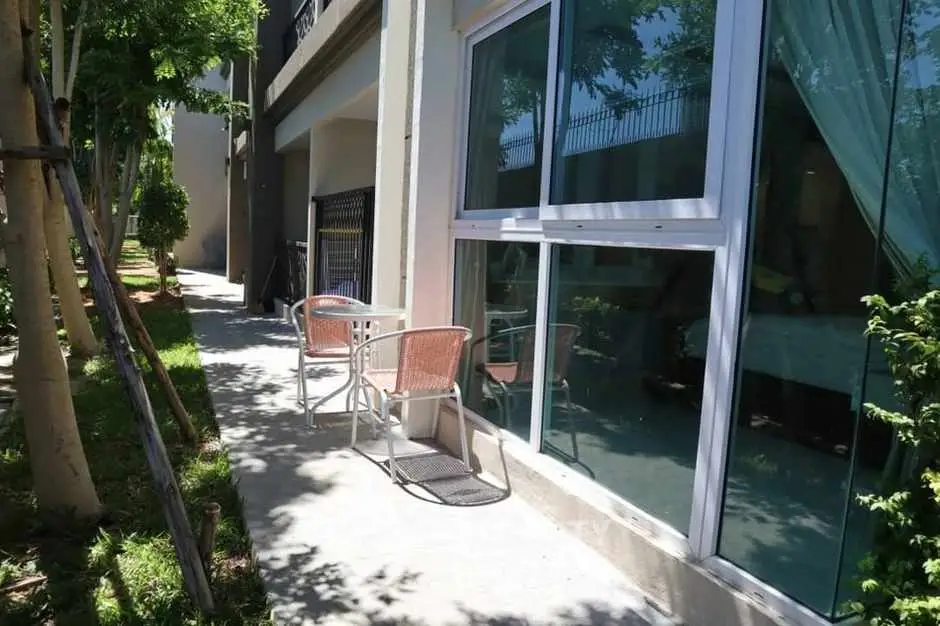 Charming outdoor patio area with seating and lush greenery, perfect for relaxation.