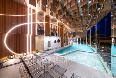 Luxurious indoor pool area with modern lighting and stylish seating in a high-end residential building.