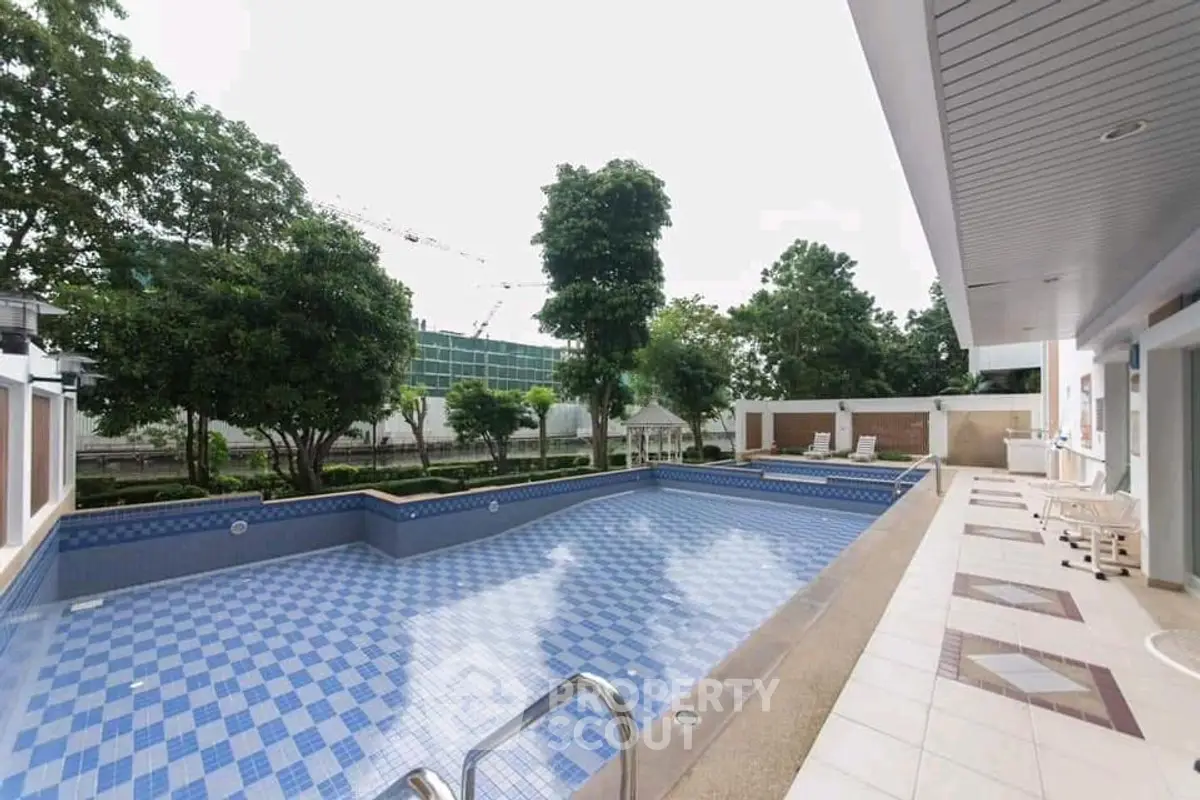 Spacious outdoor pool area with modern design and lush greenery