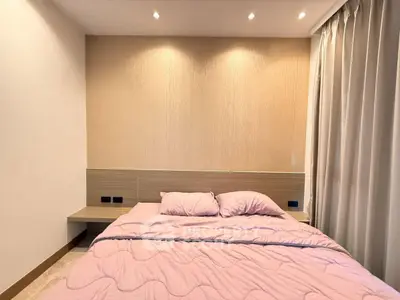 Cozy bedroom with modern lighting and elegant curtains, perfect for relaxation.