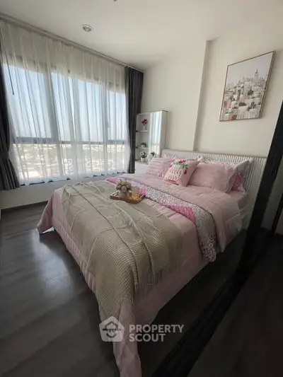 Cozy bedroom with large window and stylish decor in modern apartment.