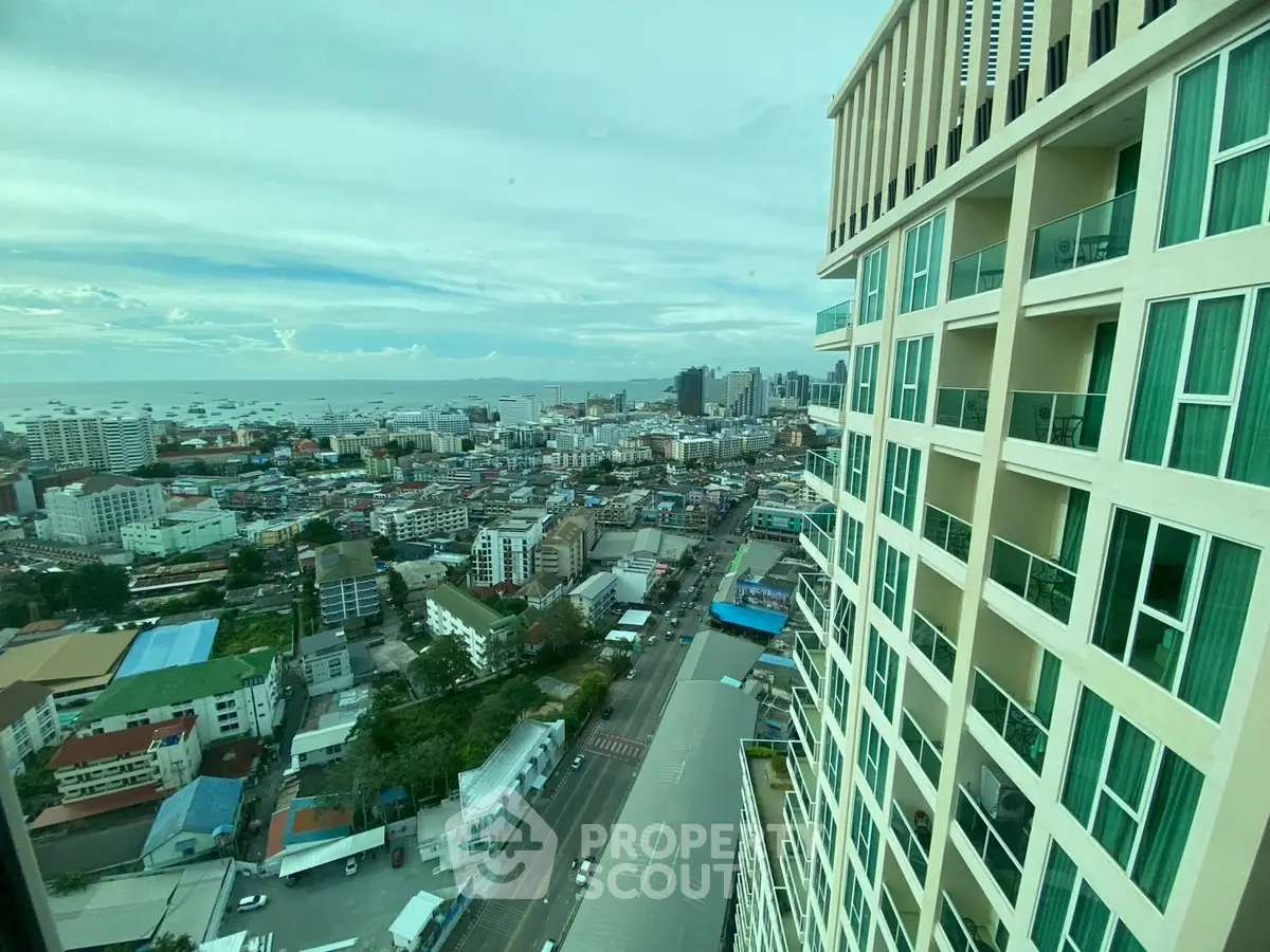 Stunning cityscape view from high-rise building with ocean in the background.