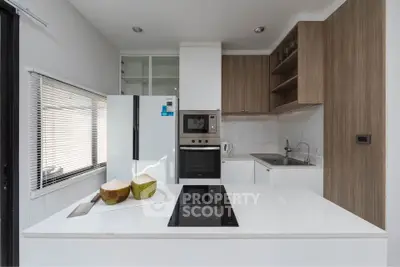 Modern kitchen with sleek design, featuring built-in oven and induction cooktop, perfect for culinary enthusiasts.