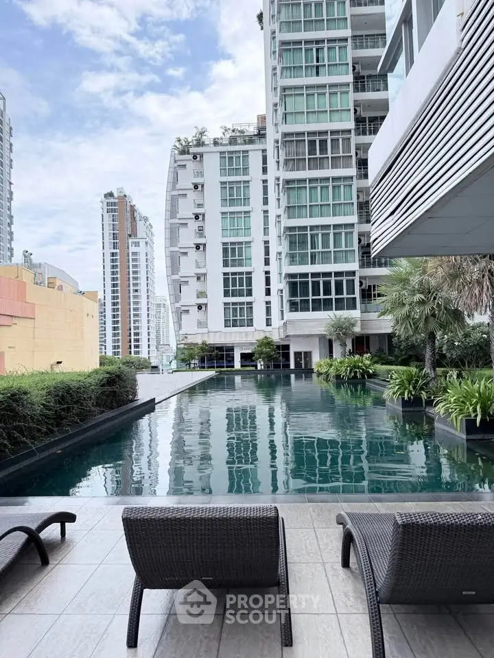 Luxurious high-rise building with stunning pool and city view, perfect for urban living.