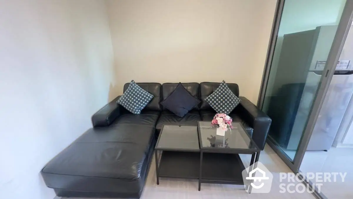 Modern living room with black leather sofa and glass coffee table