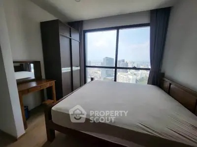 Spacious bedroom with city view, featuring a large window, wooden bed, and wardrobe, perfect for urban living.