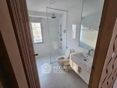 Modern bathroom with glass shower and sleek fixtures in a bright apartment.