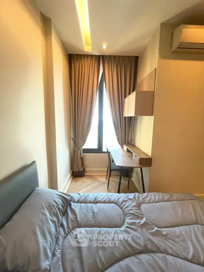 Cozy bedroom with modern decor, featuring a study desk and large window with elegant curtains.