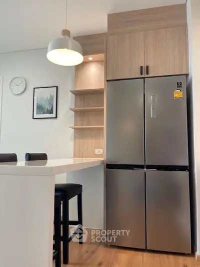 Modern kitchen with sleek fridge and stylish pendant light