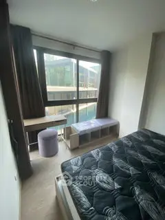 Modern bedroom with large window and stylish furniture overlooking a scenic view.