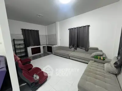 Spacious living room with modern furniture and tiled flooring, perfect for relaxation and entertainment.