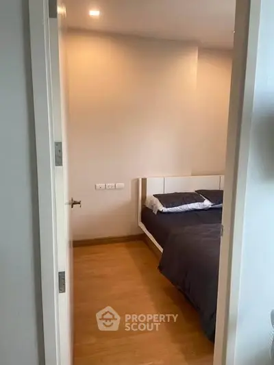 Cozy bedroom with wooden flooring and modern bed, perfect for relaxation.