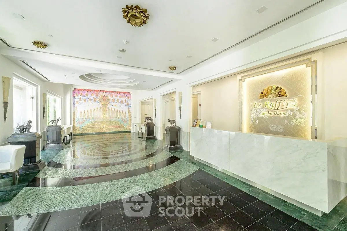 Luxurious building entrance with elegant marble flooring and artistic wall mural.