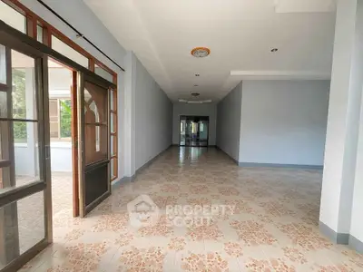 Spacious interior with tiled flooring and large windows in a modern real estate property.