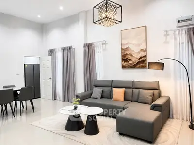 Modern living room with stylish gray sofa, chic lighting, and elegant decor in a spacious open layout.