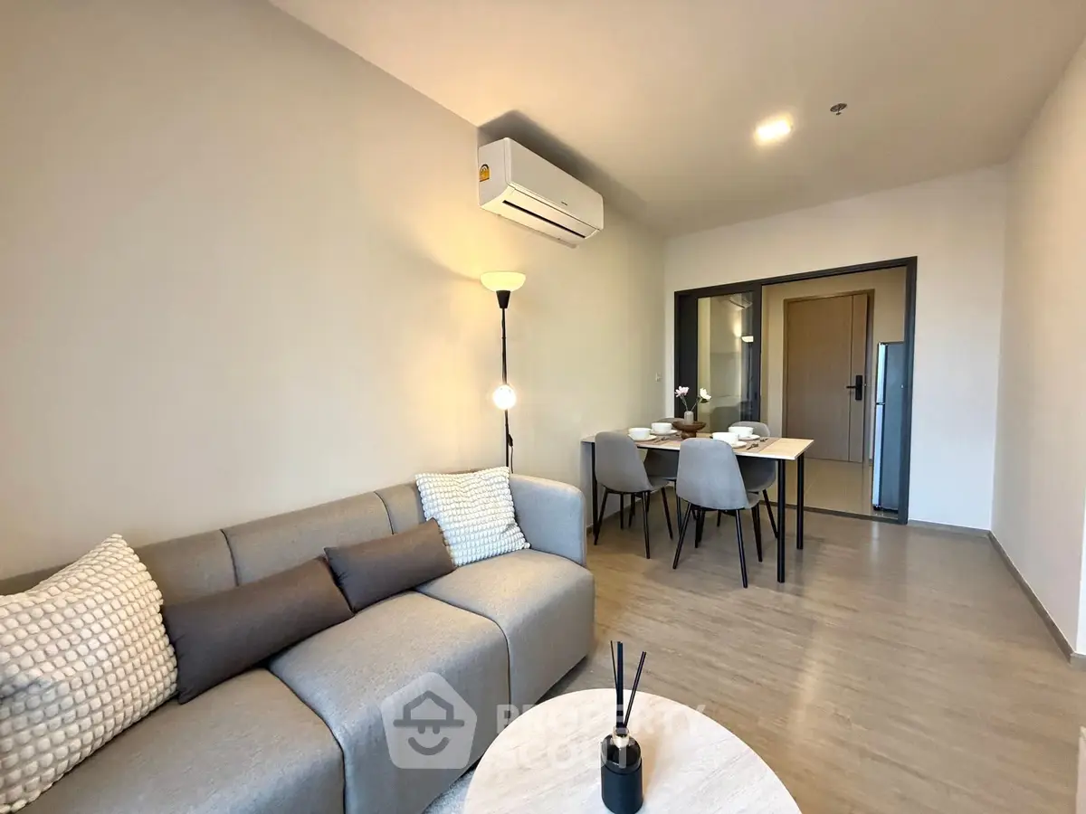 Modern living room with cozy sofa and dining area in open layout apartment.