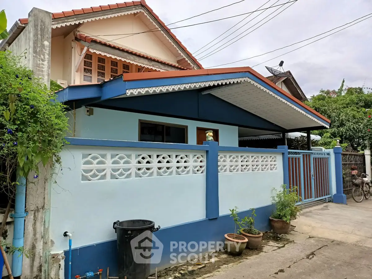 Charming single-story home with blue accents and decorative fencing in a serene neighborhood.
