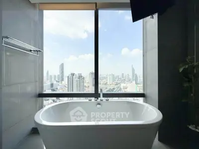 Luxurious bathroom with stunning city view from large window and modern bathtub.