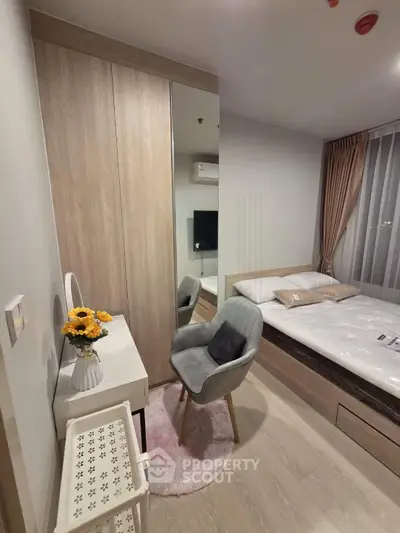 Cozy bedroom with modern decor, featuring a stylish chair, vanity, and a comfortable bed with soft lighting.