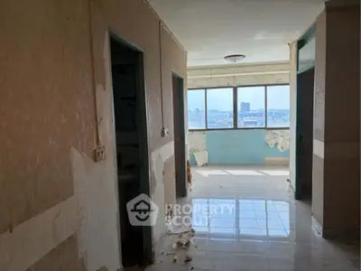 Spacious apartment hallway with large windows and city view, ideal for renovation.