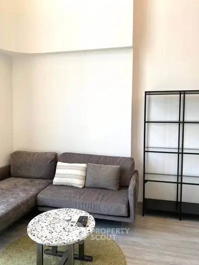Modern living room with stylish gray sofa and sleek shelving unit