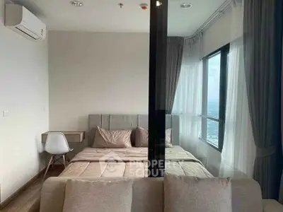 Modern bedroom with large windows and neutral decor in high-rise apartment.