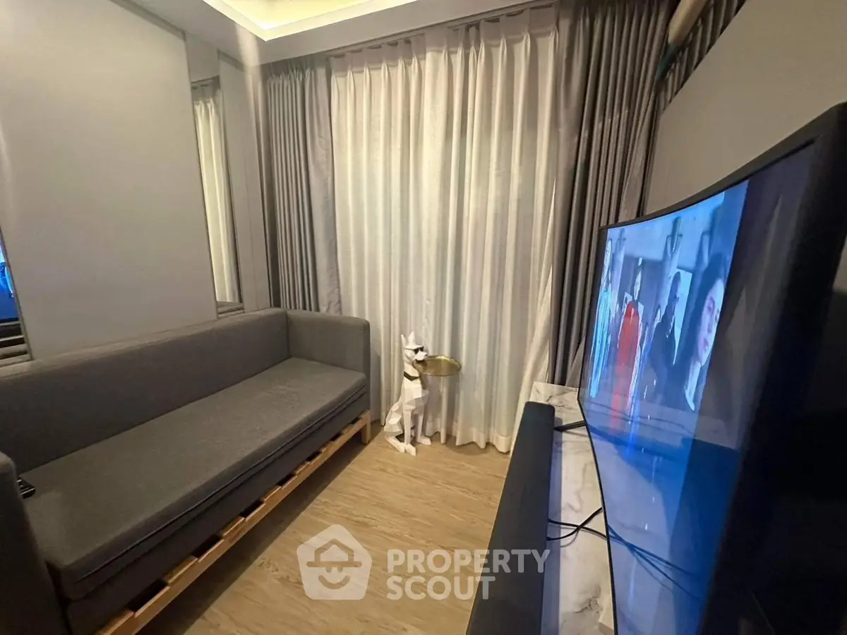 Cozy living room with modern decor and flat-screen TV, perfect for relaxation.